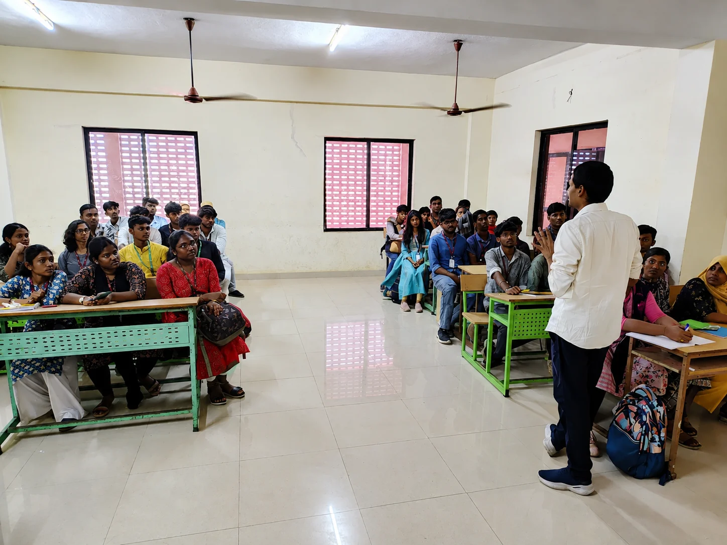 An instructor addressing seated students in a college classroom